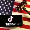 Logo của ứng dụng TikTok trên điện thoại và quốc kỳ Mỹ. Ảnh: Reuters/TTXVN