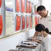 Công chức thuế hướng dẫn người dân làm thủ tục kê khai thuế. Ảnh: Dũng Minh