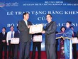 Đại diện Coteccons (trái) đón nhận Bằng khen do có nhiều thành tích đóng góp xây dựng và phát triển TTCK, ngày 25/7/2015