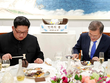 Ông Kim và ông Moon dùng búa nhỏ đập vỡ món bánh có bản đồ bán đảo Triều Tiên trên bàn tiệc. Ảnh: AFP