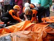 Lực lượng cứu hộ Indonesia bên cạnh túi đựng thi thể nạn nhân sáng 24/12. Ảnh: AFP.