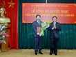GS.TS. Nguyễn Xuân Thắng (phải) trao quyết định và tặng hoa chúc mừng đồng chí Nguyễn Duy Bắc