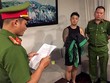 Nhà chức trách đọc lệnh bắt một người trong đường dây đánh bạc. Ảnh: Cơ quan điều tra Bộ Công an.