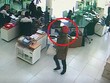 Tên cướp (khoanh tròn đỏ) cầm bao tải trắng tiến thẳng vào quầy gom tiền. Ảnh: Cắt từ camera.