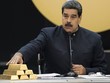 Tổng thống Maduro chạm vào các thỏi vàng trong cuộc họp với các bộ trưởng phụ trách lĩnh vực kinh tế ở Caracas tháng 3/2018. Ảnh: Reuters.