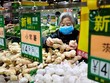 Một phụ nữ chọn gừng trong siêu thị ở Bắc Kinh hồi tháng 4. Ảnh: Reuters.