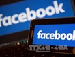 Biểu tượng Facebook trên màn hình điện thoại và máy tính. Ảnh: AFP/TTXVN.