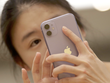 Một người tiêu dùng Trung Quốc sử dụng iPhone 11. (Nguồn: Reuters).