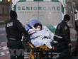 Nhân viên y tế chuyển bệnh nhân COVID-19 tới bệnh viện ở New York, Mỹ. (Ảnh: THX/TTXVN).