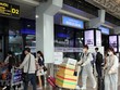 Để phòng chống dịch, nhiều hành khách đã chủ động trang bị các bộ đồ bảo hộ khi đến sân bay Tân Sơn Nhất. (Ảnh: Tiến Lực/TTXVN).