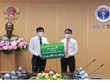 Đại diện Vietcombank, đ/c Nghiêm Xuân Thành – UV BCH TW Đảng, Uỷ viên BTV Đảng ủy khối DNTW, Bí thư Đảng ủy, Chủ tịch HĐQT Vietcombank (bên phải) trao biển tượng trưng số tiền 25 tỷ đồng hỗ trợ Bộ Y tế mua vắc xin phòng COVID-19 cho GS.TS. Nguyễn Thanh Long - UV BCH TW Đảng, Bộ trưởng Bộ Y tế.