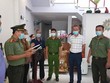 Thi hành quyết định khởi tố bị can, bắt tạm giam đối với Lee Kwan Young (áo trắng). (Ảnh: Công an cung cấp).