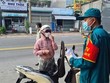 Lực lượng chức năng vận động người dân quay trở lại nơi tạm trú. (Ảnh: Chí Tưởng/TTXVN).