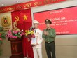 Thứ trưởng Lương Tam Quang trao quyết định và tặng hoa chúc mừng Đại tá Vũ Hoài Bắc.