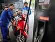 Khách hàng đổ xăng tại một trạmtrên đường Lê Thánh Tôn (TP HCM).