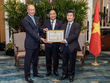 Ông Wee Ee Cheong, Phó chủ tịch kiêm Tổng giám đốc tập đoàn UOB, nhận bằng khen từ ông Đỗ Nhất Hoàng, Cục trưởng Cục Đầu tư nước ngoài trước sự chứng kiến của Chủ tịch nước Nguyễn Xuân Phúc