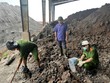 Lực lượng chức năng kiểm tra khu vực chôn lấp chất thải. Ảnh: BCA