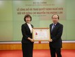 Thứ trưởng Bộ Tài chính Huỳnh Quang Hải  trao Huân chương lao động hạng nhì cho bà Nguyễn Thị Hoàng Lan. 