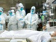 Các bác sĩ tại thành phố Vũ Hán đang chăm sóc cho một bệnh nhân nhiễm virus corona. Ảnh: REX.