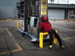 Một nhân viên ngồi thất thần tại trạm xăng Petroleos de Venezuela tại Caracas, Venezuela. (Nguồn: Wil Riera | Bloomberg | Getty Images)