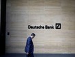 Một người đàn ông đi qua văn phòng của Deutsche Bank ở London. Ảnh: Bloomberg