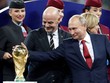 Tổng thống Nga Putin (phải) chạm vào cúp vàng World Cup sau trận chung kết hôm qua. Ảnh: Reuters. 