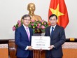 Thứ trưởng Lê Hoài Trung (phải) trao số tiền ủng hộ thông qua đại sứ Lào tại Việt Nam Thongsavanh Phomvihane. Ảnh: Bộ Ngoại giao.