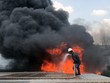 Công nhân cố dập lửa trong đám cháy. Ảnh: Tin Tin.