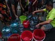 Người dân xếp hàng lấy nước sạch. (Ảnh: PV/Vietnam+).