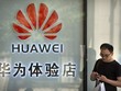 Một người đang sử dụng điện thoại bên ngoài cửa hàng Huawei ở Bắc Kinh. (Nguồn: AP)
