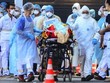 Nhân viên y tế di chuyển người nhiễm nCoV tại Pháp ngày 10/4. Ảnh: AFP.