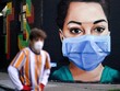 Một người đàn ông đi qua một bức vẽ mô tả một y tá đeo khẩu trang ở London, Anh. (Ảnh: Reuters).
