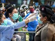 Nhân viên y tế kiểm tra thân nhiệt cho cảnh sát ở Bangkok, Thái Lan. (Nguồn: AFP/TTXVN).