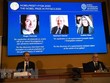 Chân dung ba nhà khoa học (trên màn hình, từ trái sang): Roger Penrose (người Anh), Reinhard Genzel (người Đức) và Andrea Ghez (người Mỹ) được xướng tên đoạt giải Nobel Vật lý 2020 tại buổi lễ ở Viện Hoàng gia Thụy Điển, thủ đô Stockholm ngày 6/10/2020. (Nguồn: AFP/TTXVN).