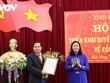 Ủy viên Trung ương Đảng, Trưởng Ban Dân vận Trung ương Bùi Thị Minh Hoài trao Quyết định và tặng hoa, chúc mừng ông Điểu K’Ré.