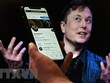 Tài khoản Twitter của tỷ phú Elon Musk trên màn hình điện thoại và ảnh chụp ông Musk (phía sau) tại một sự kiện ở Washington, DC, Mỹ ngày 14/4. (Ảnh: AFP/TTXVN)