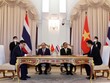 Đại diện Vietcombank, ông Nguyễn Thanh Tùng, Phó Tổng Giám đốc phụ trách Ban Điều hành (bên trái) và đại diện Eximbank Thái Lan, Ts. Rak Vorrakitpokatorn, Tổng Giám đốc (bên phải) ký kết thỏa thuận hợp tác trước sự chứng kiến của Chủ tịch nước Cộng hòa XHCN Việt Nam Nguyễn Xuân Phúc và Thủ tướng Thái Lan Prayuth Chan-ocha. Ảnh: TTXVN