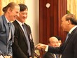 Thủ tướng Nguyễn Xuân Phúc trao đổi với ông Dominic Scriven, Chủ tịch Điều hành Công ty quản lý Quỹ Dragon Capital (bên trái) và ông Mai Hữu Tín, Chủ tịch U&I. (Ảnh: H.Phúc)