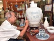 Nghệ nhân vẽ trên bình gốm Chu Đậu (Ảnh: Báo Nhân dân)