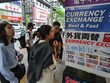 Người dân đứng bên ngoài quầy đổi tiền để xem tỷ giá đồng yên so với ngoại tệ, dọc con phố ở trung tâm Tokyo vào ngày 29/4/2024. Ảnh: AFP