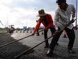 Công nhân thi công trải nhựa trên xa lộ Hà Nội (đoạn Q.2, TP.HCM). Theo kế hoạch, dự án này hoàn thành trong năm 2012 nhưng chậm đền bù giải tỏa nên có thể phải đến năm 2014 mới hoàn thành (ảnh chụp 