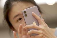 Một người tiêu dùng Trung Quốc sử dụng iPhone 11. (Nguồn: Reuters).
