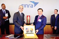 Bộ trưởng Đinh Tiến Dũng tặng quà cho Tổ chức Finra, Tổ chức giữ gìn sự liêm chính trên thị trường chứng khoán Mỹ, trong chuyến xúc tiến đầu tư tại New York, tháng 7/2015