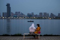 Một cặp đôi ngồi bên bờ sông ở Vũ Hán. Cuộc sống ở Vũ Hán đang dần trở lại bình thường sau đợt bùng phát dịch Covid-19. Ảnh: Xinhua.