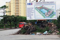 Bảng thông tin hướng dẫn chi tiết về dự án Khu nhà ở Vĩnh Hoàng, phía dưới là một bãi rác