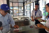 Khách sử dụng thẻ vé điện tử qua cổng kiểm soát để lên xe buýt nhanh BRT 01 Kim Mã-Yên Nghĩa. (Ảnh: Việt Hùng/Vietnam+).