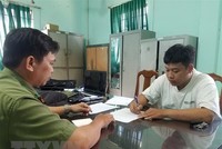 Công an làm việc với Trần Văn Tùng. (Ảnh: TTXVN).