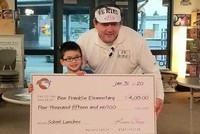 Cậu bé Keoni Ching trao số tiền 4.015 đô la Mỹ cho trường tiểu học Benjamin Franklin để trang trải tiền nợ ăn trưa cho bạn học.