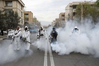 Nhân viên cứu hỏa trong trang phục bảo hộ khử trùng đường phố ở thủ đô Tehran, Iran, ngày 18/3. Ảnh: Reuters.