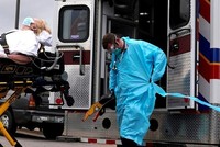 Nhân viên y tế chuẩn bị đưa bệnh nhân Covid-19 lên xe cứu thương ở Oklahoma, Mỹ, tháng trước. Ảnh: Reuters.
